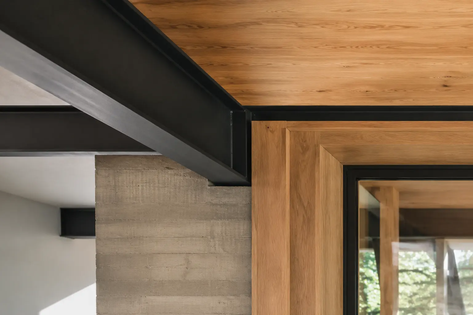 Detail of wood, concrete, and steel materials meeting at a clean junction